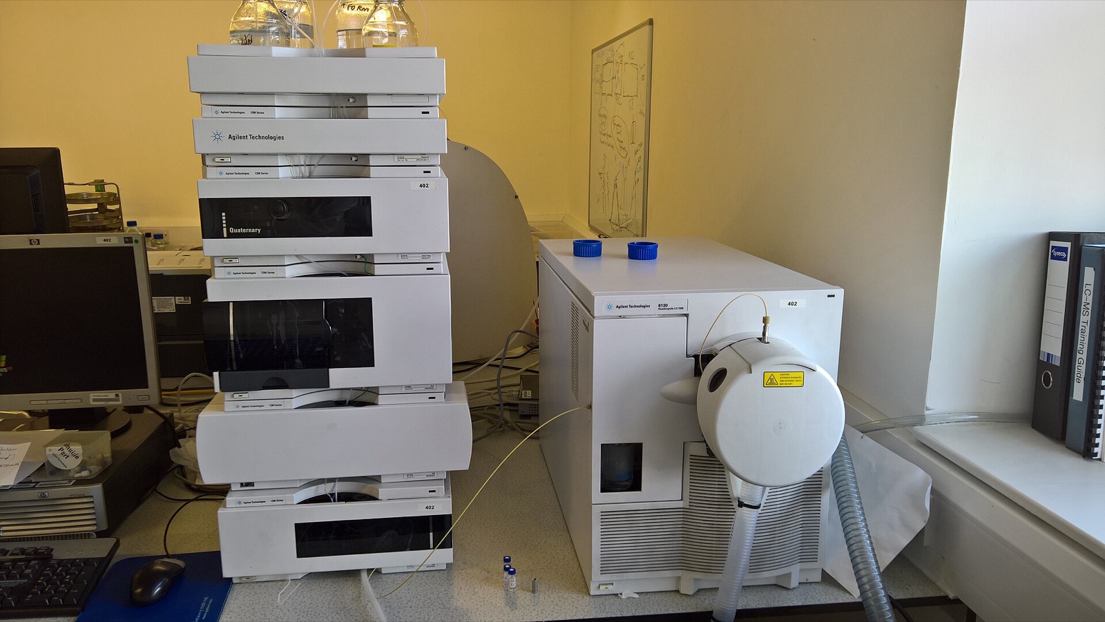 A liquid chromatography stack beside a quadrupole mass spectrometer on a laboratory bench