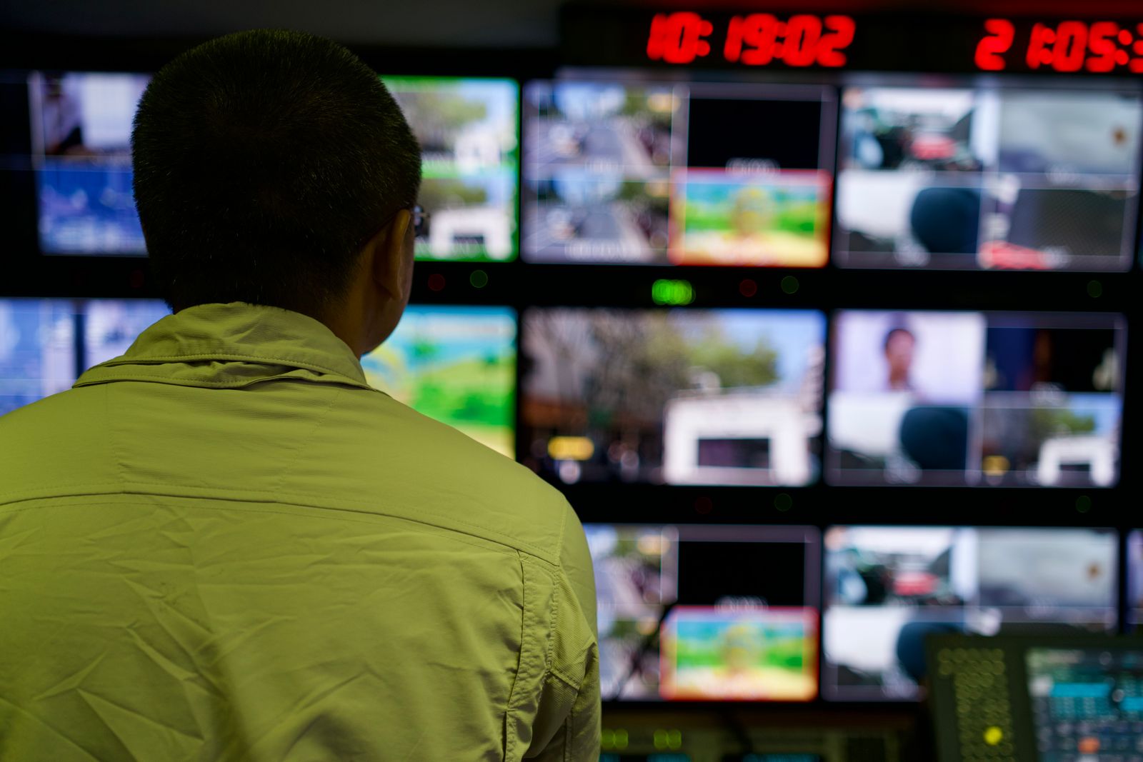 An operator watching a wall of live feeds in a broadcast gallery