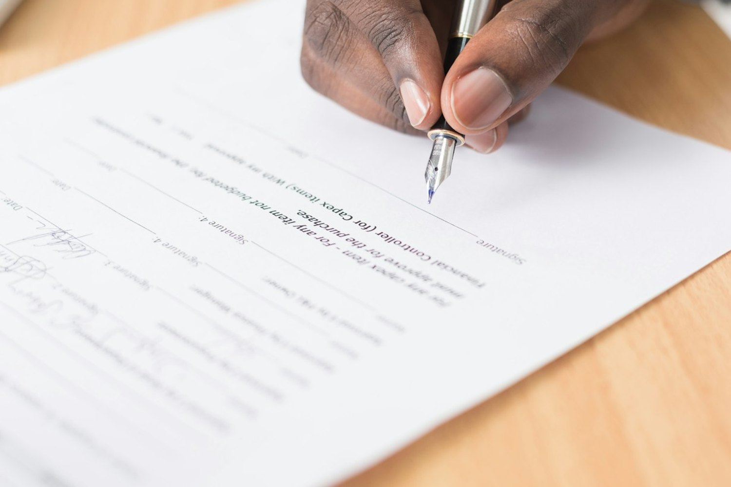 A director signing off a printed letter with a fountain pen