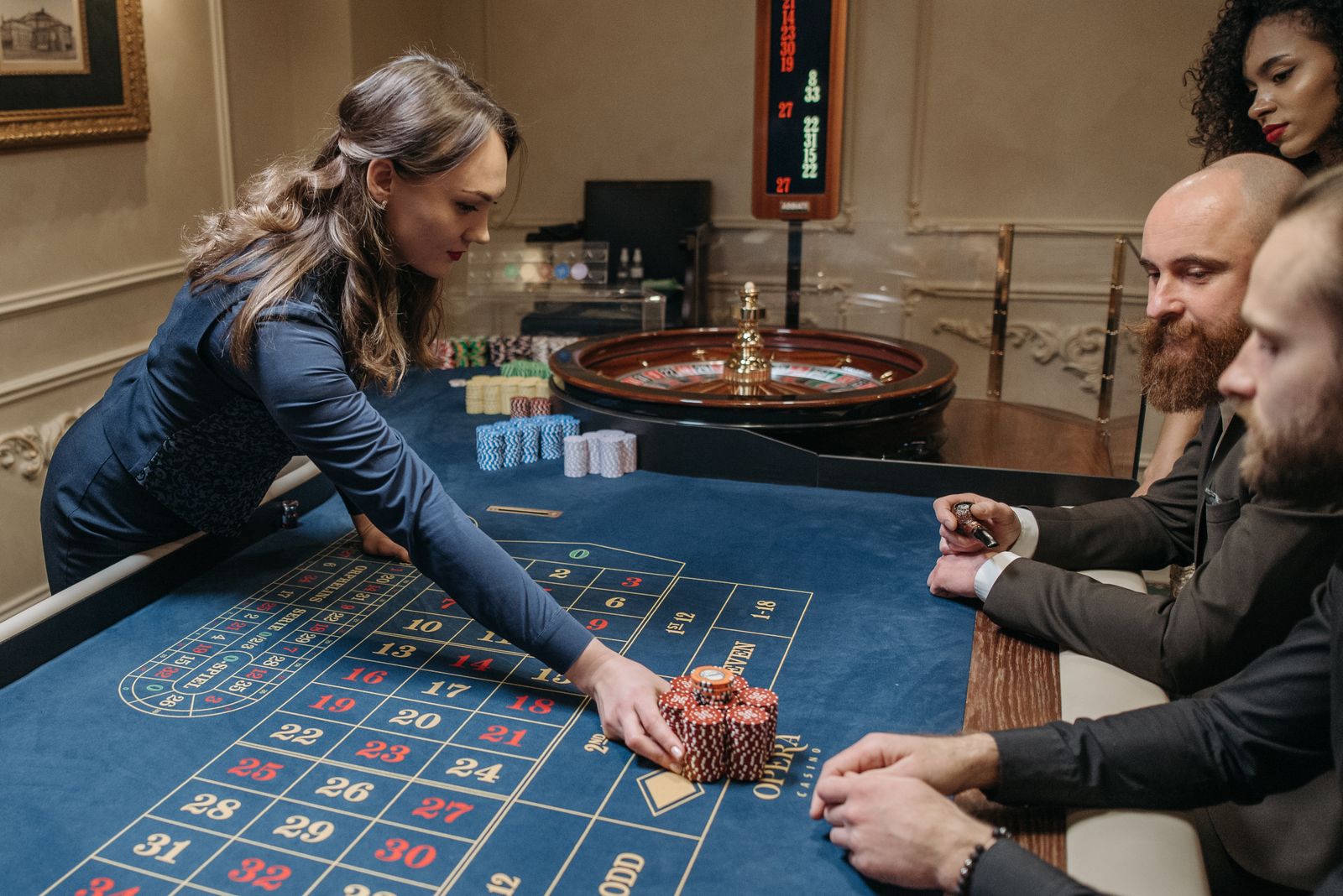 A dealer managing chips across a roulette table mid-game